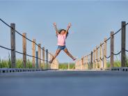 Girl jumping on bridge